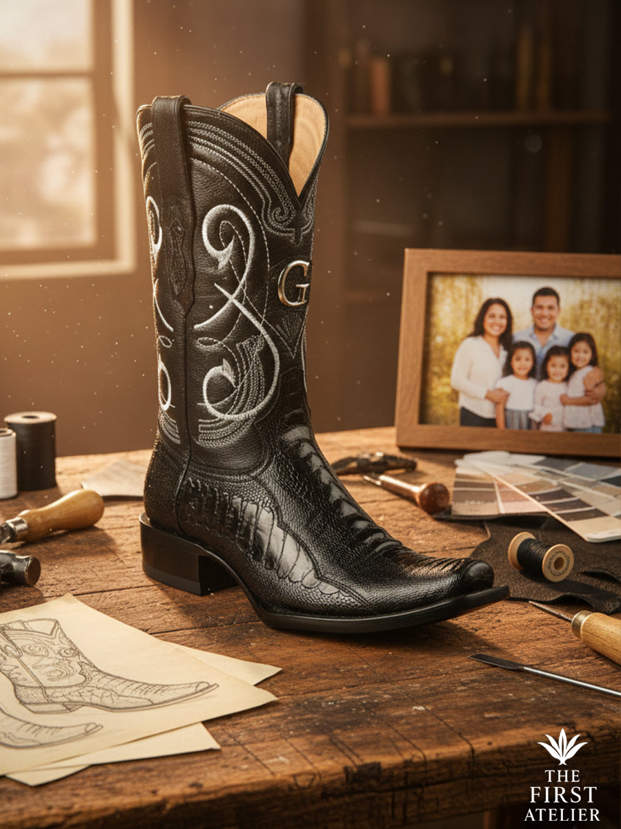 Finished Atelier No. 58 “El Meridiano” black ostrich leather boot displayed in the atelier with sketches and tools, showcasing refined quill texture and handcrafted finishing.
