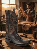 The First Atelier Atelier No. 60 “El Ascenso” men’s western boot in brown ostrich leather on an artisan workbench, showcasing natural quill texture, tonal embroidery, and handcrafted finishing.
