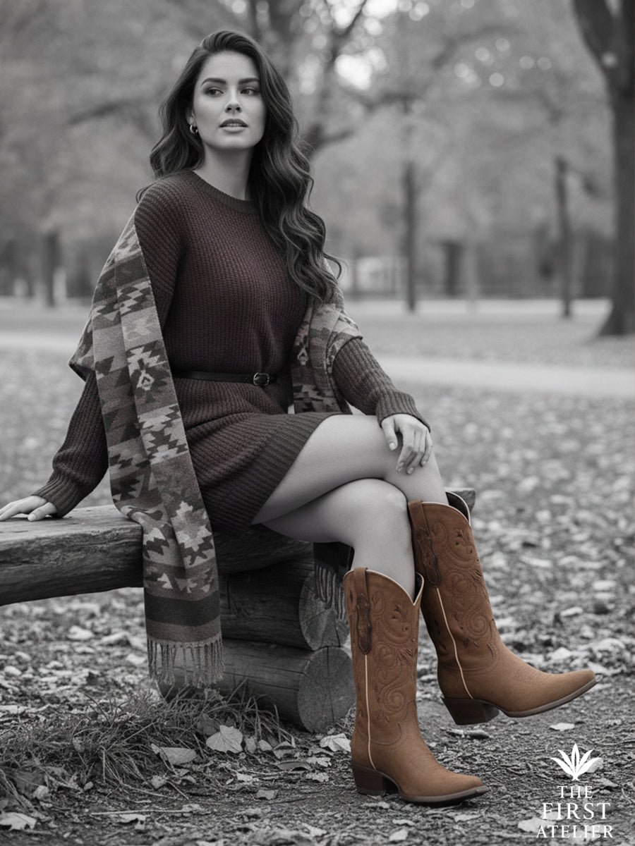 Black-and-white portrait seated on a park bench — La Rosa del Arno Boot paired with a soft knit and printed coat, quiet elegance