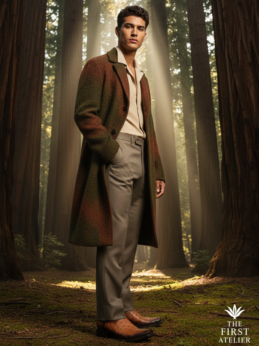 Man standing quietly among tall trees wearing The First Atelier Atelier No. 48 men’s western boots in cognac ostrich leather — warm leather tones softened by forest light, composed posture, and reflective presence.
