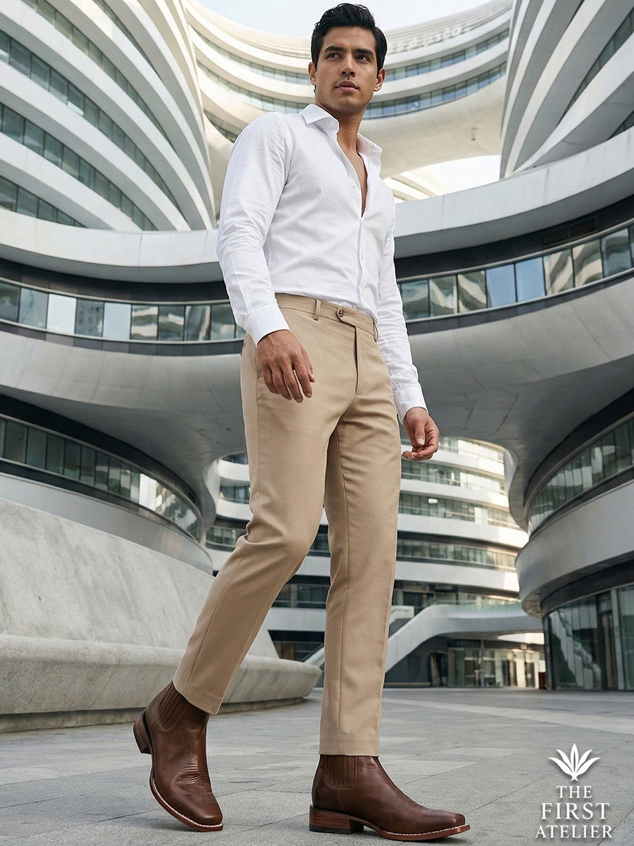 Full body shot of a man wearing Atelier No. 68 El Trazo Maestro Boot in brown leather with beige trousers in a futuristic urban plaza.