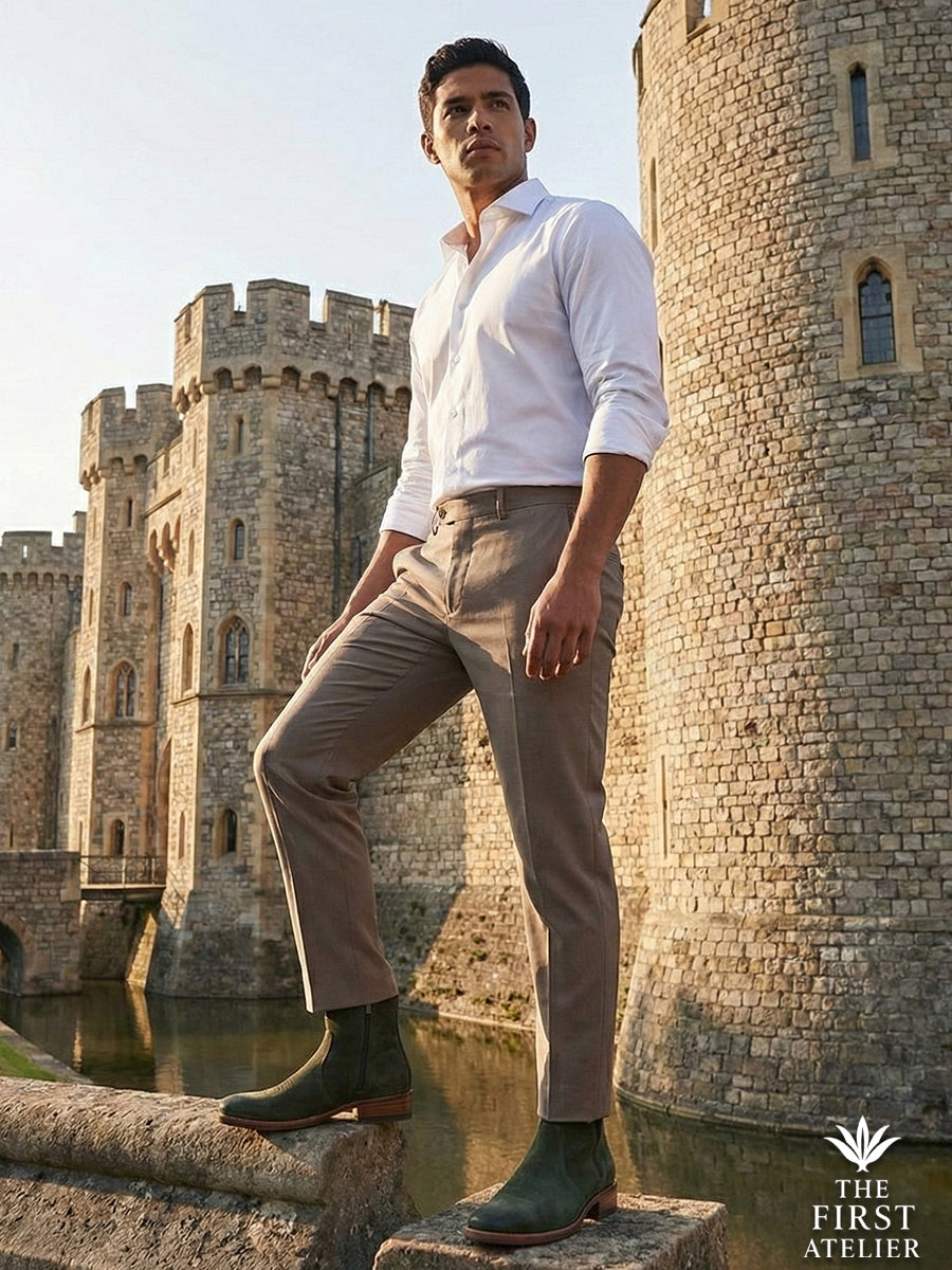 Man standing on the stone walls of a historic fortress wearing Atelier No. 70 El Dominio Boot in olive green with light trousers.