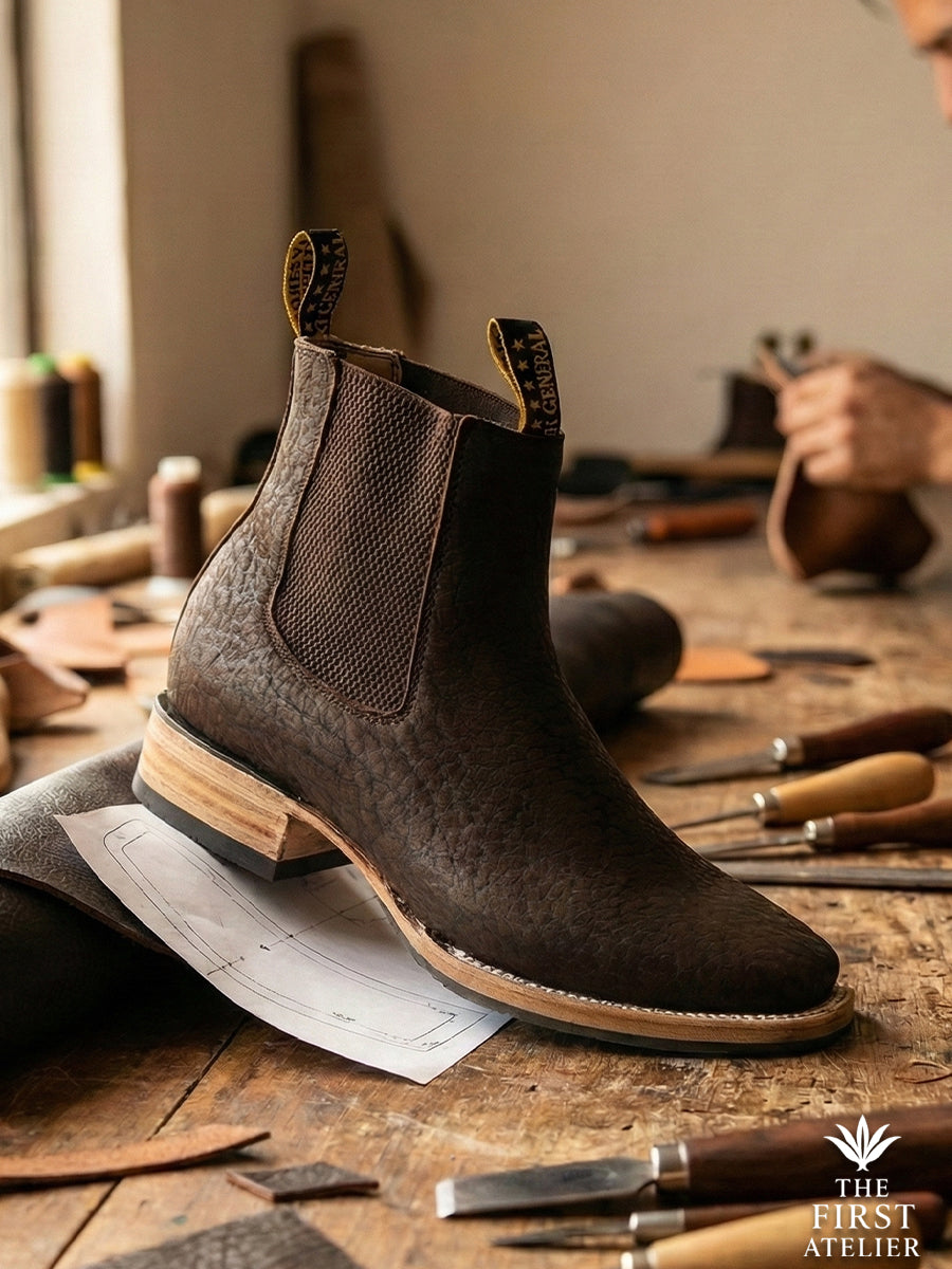 Close-up of Atelier No. 72 El Roble Boot showing the deep, pebbled texture of the dark brown bullneck leather in the artisan workshop