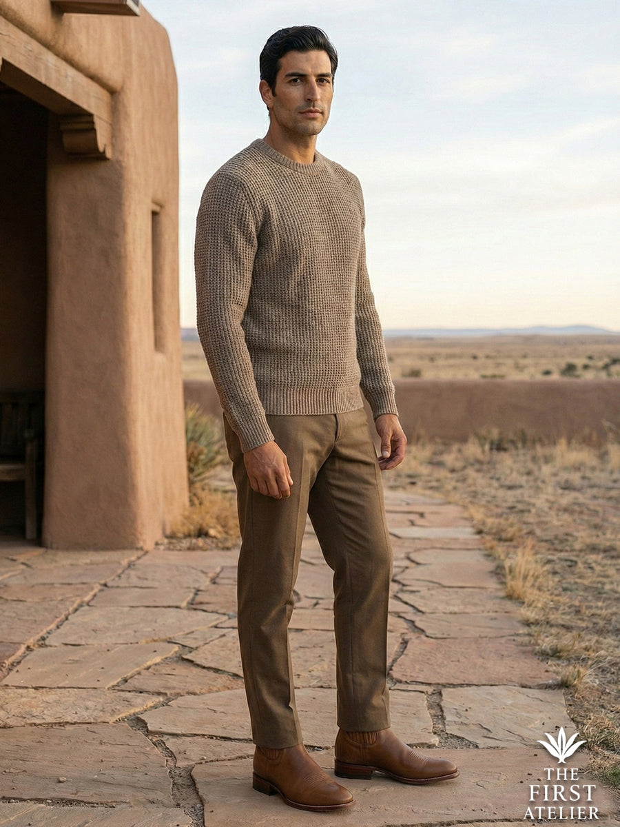 Man standing outside an adobe home wearing Atelier No. 75 El Rumbo Boot, showcasing the leather's natural connection to earth tones.