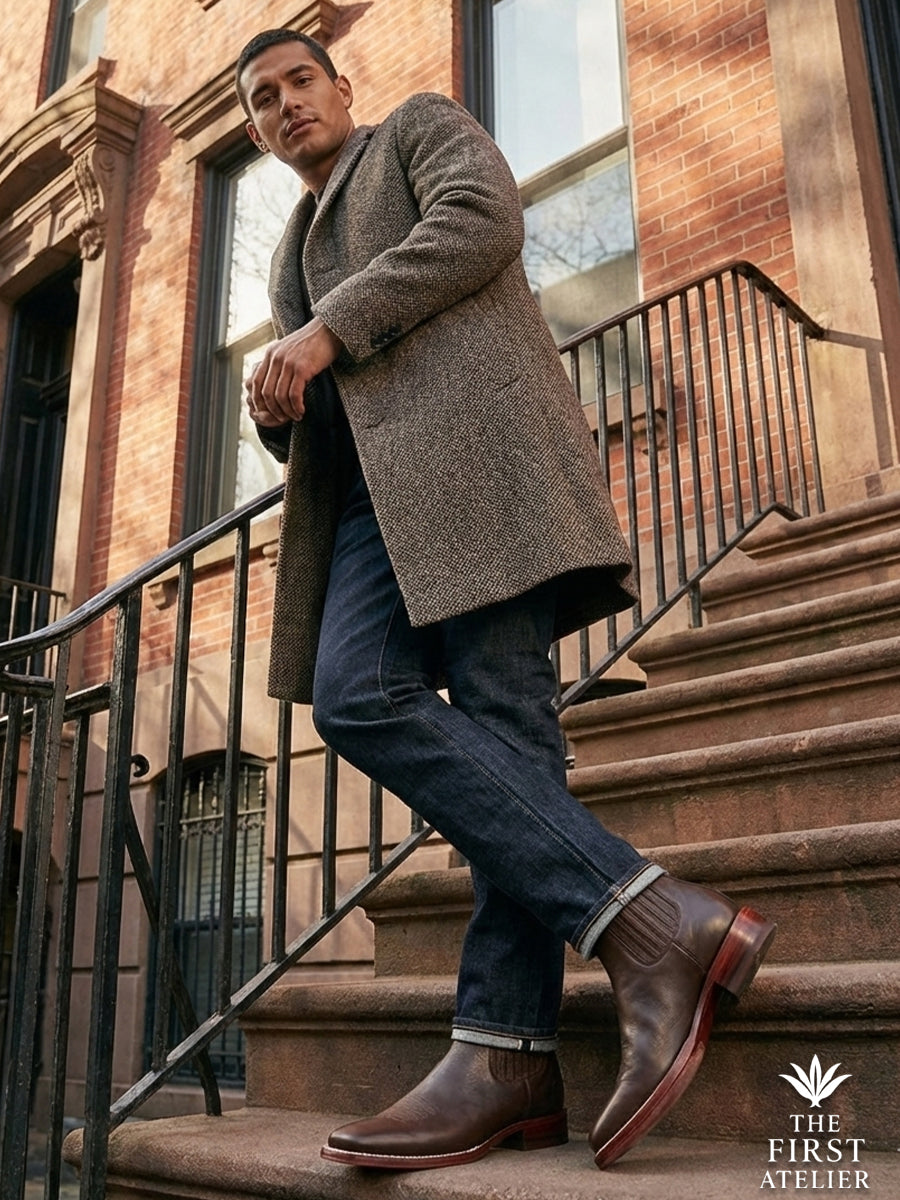 Elegant winter styling: Gentleman in a textured brown coat standing on city steps wearing the robust Atelier No. 76 leather boot.