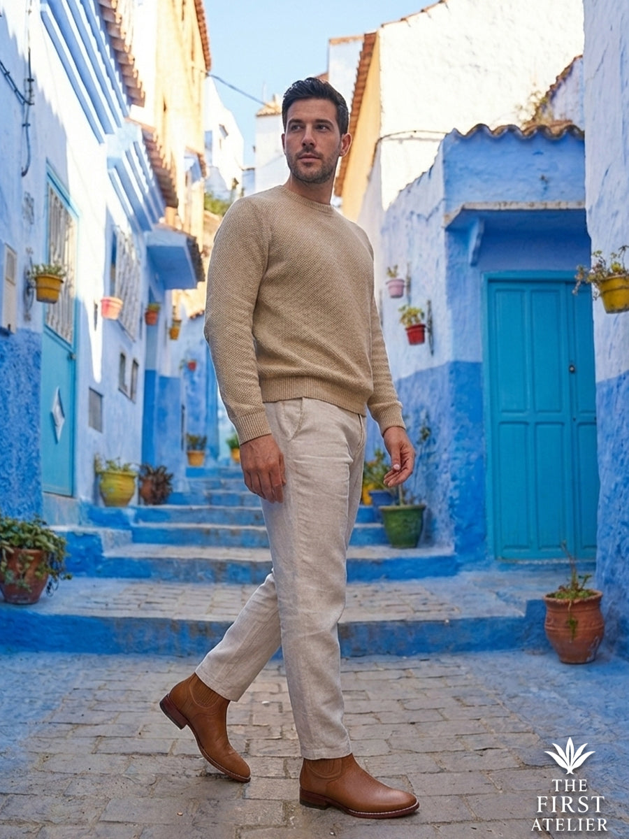 Man walking through a vibrant blue-walled street in summer linen, wearing the textured cognac Atelier No. 77 El Atlas Boot.