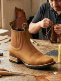 Close-up of Atelier No. 80 El Jinete Boot showing the heavy-duty rubber lug sole and oiled tan leather construction in the workshop.