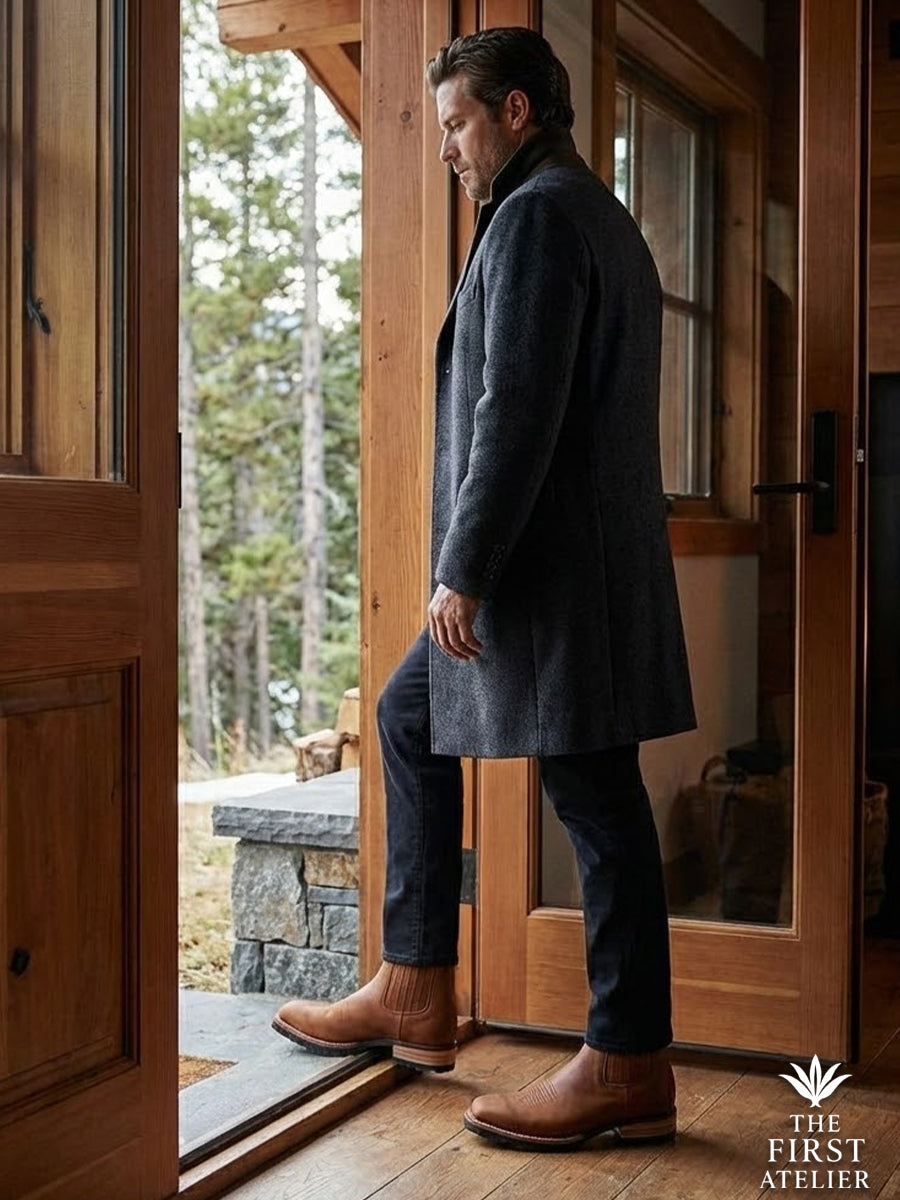 Man entering a luxurious wooden mountain cabin wearing a long wool coat and the durable Atelier No. 81 winter boot.