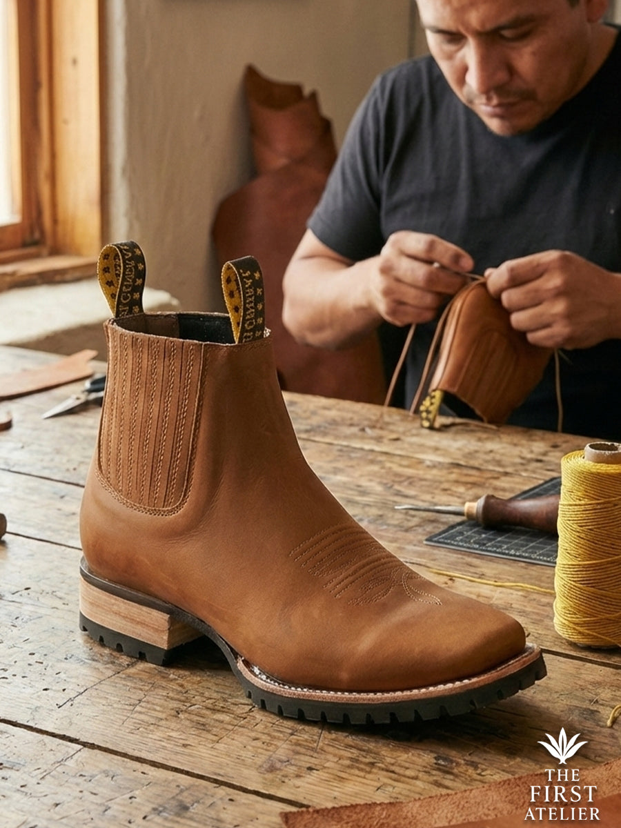 Artisan in the workshop crafting the Atelier No. 81 El Glaciar Boot, showcasing the thick rubber lug sole designed for cold weather.