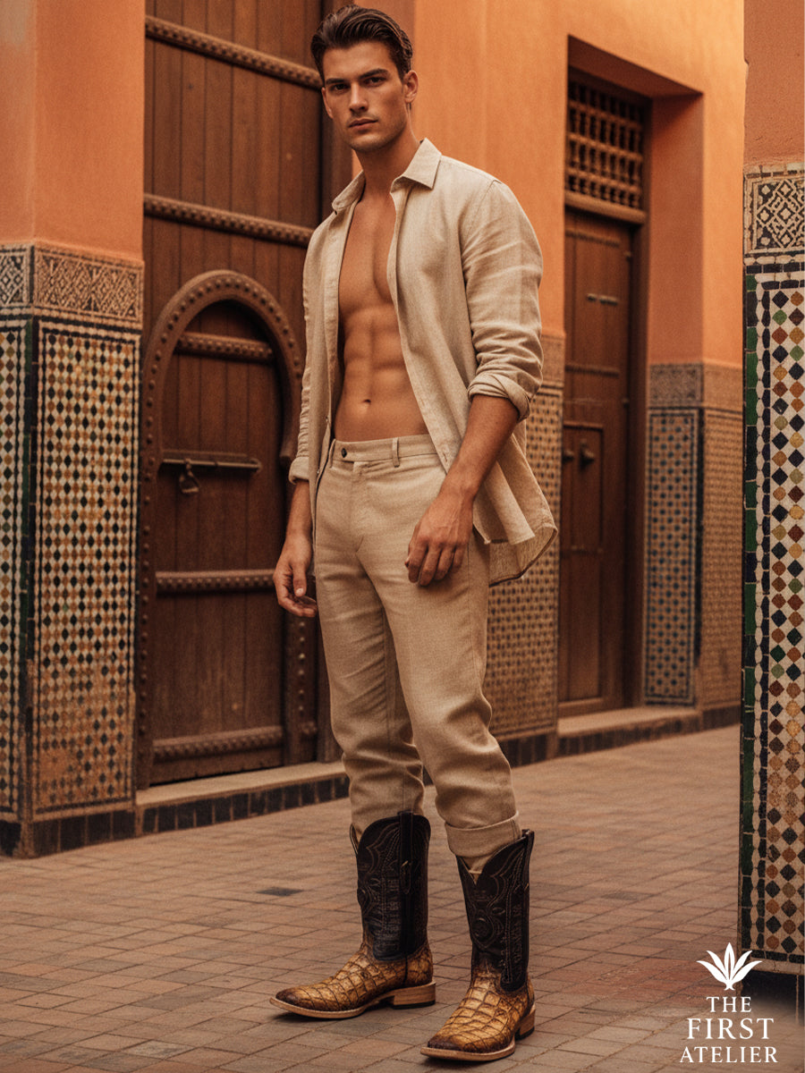 Man standing on an architectural street wearing the El Umbral Boot in textured brown leather, highlighting a strong western silhouette framed by traditional craftsmanship and urban structure, Atelier No. 33.
