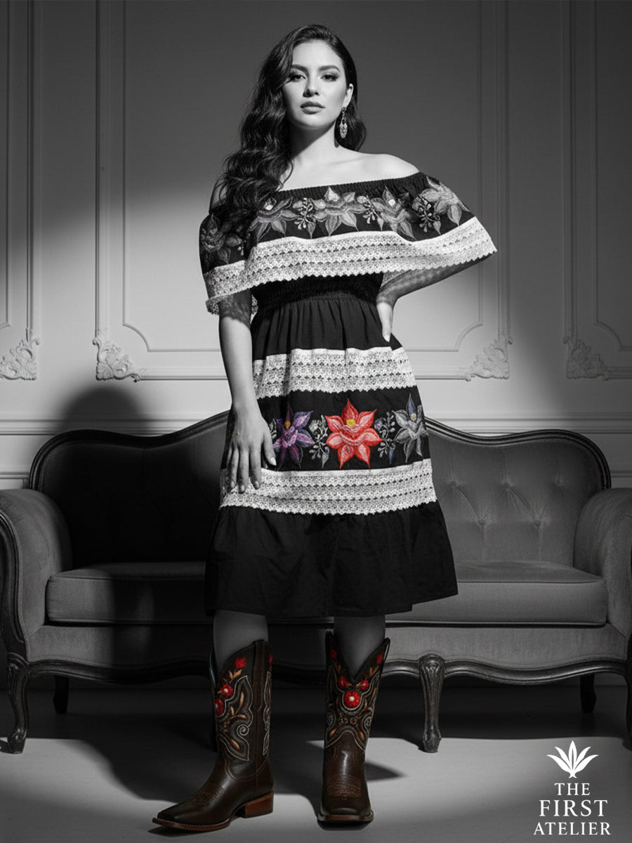Black-and-white editorial photo of a confident Latina muse in an off-shoulder dress and La Flor de Fuego Boot, capturing classic elegance with a modern Mexican soul, Atelier No. 02.